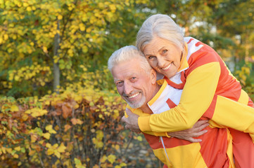 Happy fit senior couple in autumn park