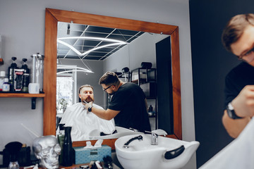 Hairdresser with a client. Man with a beard. Guy in a barbershop