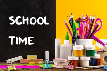 Stationery on a table on bright yellow paper background