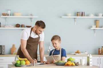 Portrait of happy father and son cooking in kitchen