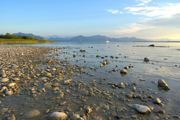 Weitwinkelaufnahme vom Chiemsee mit Blick auf die Alpen während der Goldenen Stunde