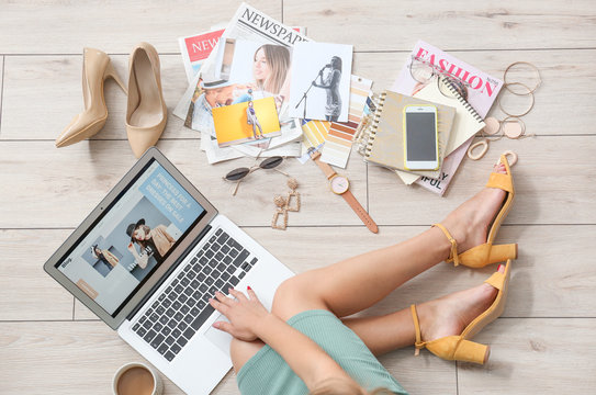 Female beauty blogger with laptop sitting on wooden floor, top view