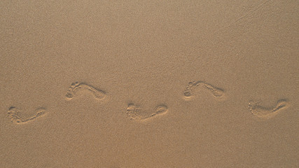 human footprints in the fine sand at the beach
