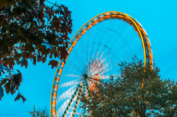 Ferris wheel in motion against blue sky