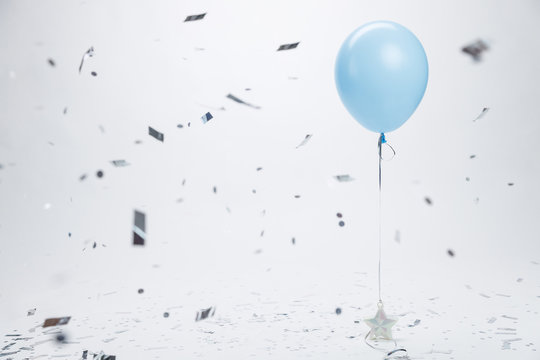 Blue Balloon Surrounded By Silver Confetti On White Background. Birthday And Holidays Background.