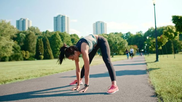 Beautiful woman warming up before workout early in the morning