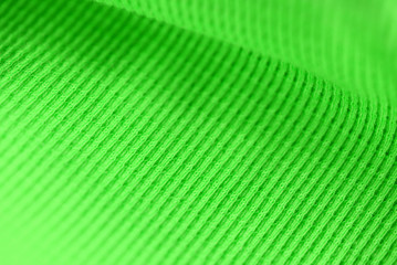 Textile surface of bright green color close-up. Abstract background
