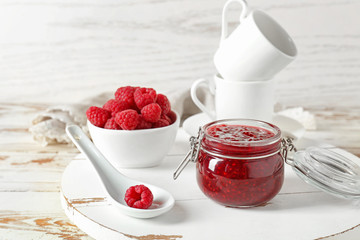 Tasty raspberry jam on white wooden table