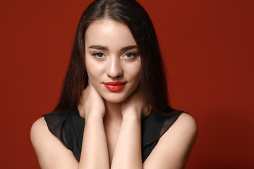 Beautiful young woman with bright lipstick on color background