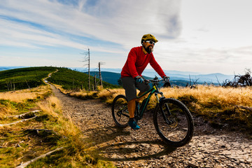 Cycling man riding on bike at sunset mountains forest landscape. Cycling MTB enduro flow trail...