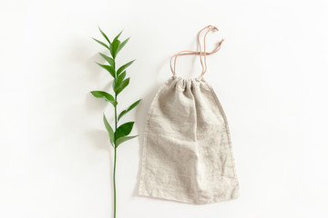 Ruscus branch and canvas bag on white background