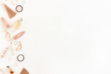 Border frame made of cosmetics, earrings, rings, hairpins on white background