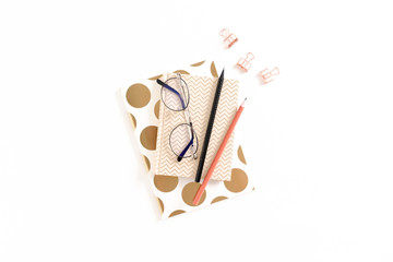 Composition with notepads, stationery and glasses on white background