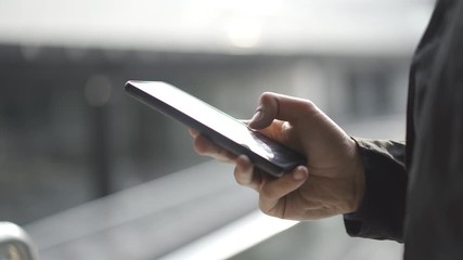 Young man using apps on a touchscreen smartphone - Concept for using technology, shopping online, using mobile apps, texting, phone addiction. - Powered by Adobe