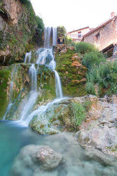 Famous waterfalls with silk effect with a crystalline water running between the houses and flowing  to the Ebro river in Orbaneja del Castillo (Burgos, Spain)