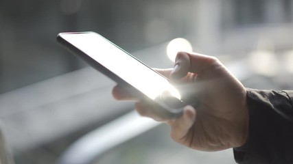 Young man using apps on a touchscreen smartphone - Concept for using technology, shopping online, using mobile apps, texting, phone addiction. - Powered by Adobe