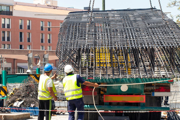 Steel rebars. Construction worker unload from the truck a part of einforcement steel prefabrication a steel reinforcements for bridge renovation with the help of a construction crane.