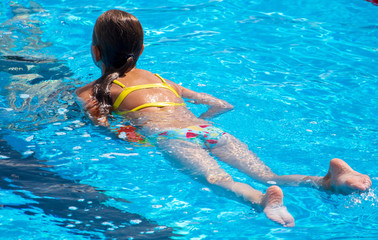 Girl in a swimsuit bathes in the pool