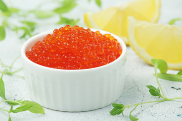 A small ceramic bowl with red caviar