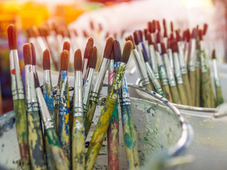 Obraz premium Artist paint brushes. Many artist tools in plastic bucket.