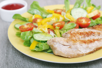Grilled chicken breast with raw vegetables salad