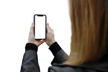 girl holds a phone in her hands and takes pictures