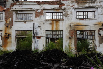 Destroyed brick wall with windows at an old factory in Siberia