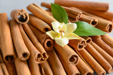 Aromatic cinnamon sticks and flower on table, closeup