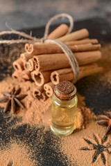 Fototapeta na wymiar Cinnamon essential oil, powder and sticks on table