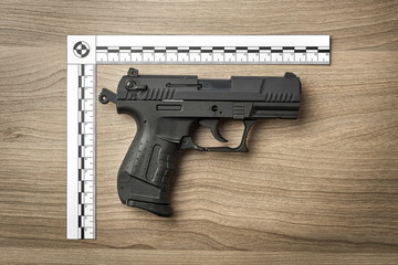 Crime Scene Investigation - handgun as a piece of evidence placed with forensic ruler for documentation - obrazy, fototapety, plakaty