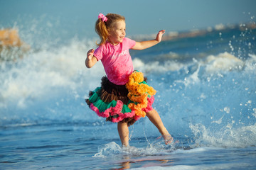 Little girl at the sea. A child runs on the waves. 