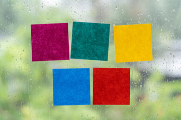 Blank colorful adhesive note stick on windows in raining day