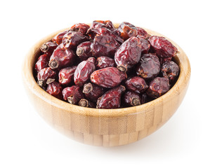 Dried wild rose berries in wooden bowl isolated on white background with clipping path