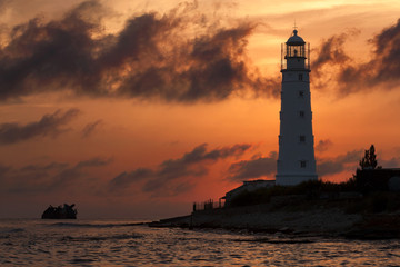 Lighthouse and shipwreck at Cape Tarkhankut, Crimea in the last rays of the sun