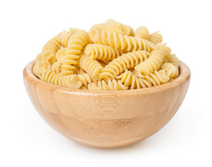 Uncooked fusilli pasta in wooden bowl isolated on white background with clipping path