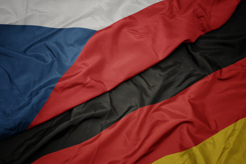 waving colorful flag of germany and national flag of czech republic.
