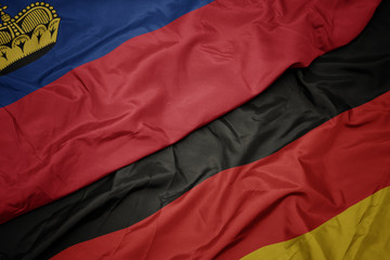 waving colorful flag of germany and national flag of liechtenstein.