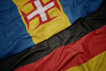 waving colorful flag of germany and national flag of madeira.