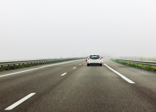 FRANKFURT, GERMANY - NOV 23, 2017: Rear View Of White Volvo V60 Car Driving On German Autobahn - Fast Motion In Safety Condition During Heavy Mist