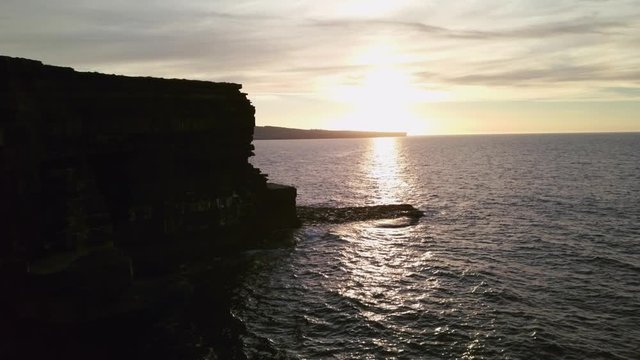 AERIAL DOLLY IN Flying alongside spectacular Carrowmore Lacken cliff at sunset