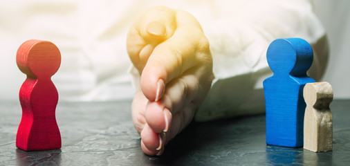 The hand separates the father with the child from the mother. The decision of the court who will become the guardian of the child. The process of divorce. Guardianship. Deprivation of parental rights
