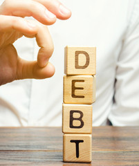 Businessman removes wooden blocks with the word Debt. Reduction or restructuring of debt....