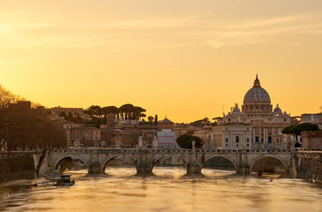 Fototapeta na wymiar St. Peter's cathedral and Tiber river with high water at sunset. Saint Peter Basilica in Vatican city with Saint Angelo Bridge in Rome, Italy