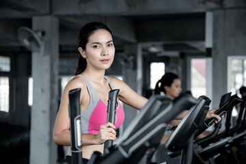 Fototapeta na wymiar Asian sexy women are exercising with the cardio in the gym.