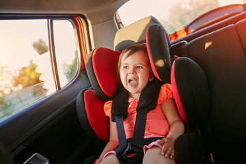 Adorable baby in safety car seat.