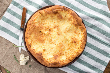 Georgian cheese bread khachapuri imeruli on round plate on tablecloth