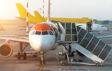 Passenger plane in the airport at sunrise. Aircraft maintenance.