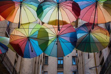 A small street in Bucharest covered by colorful umbrellas or parasols.