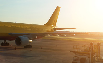 Cargo airplane on the runway at sunset.