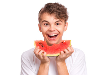 Portrait of teen boy eating ripe juicy watermelon and smiling. Cute caucasian young teenager with slice healthy watermelon. Funny happy child wearing white t-shirt, isolated on white background.